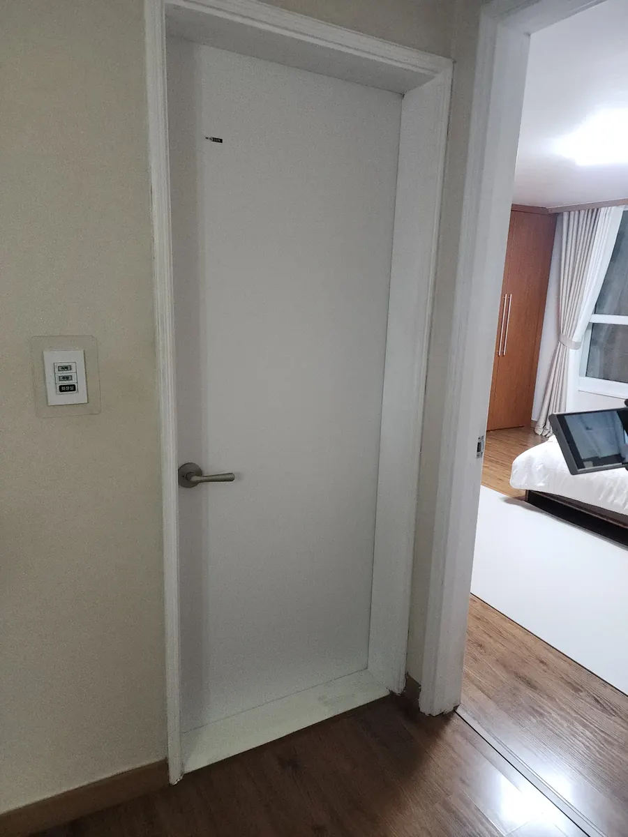문짝 문틀 교체 — 새로 단 평평한 흰색 문